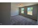 Bright bedroom featuring plush carpeting, two windows that provide natural light, and neutral wall paint at 293 Gregory Village Dr, Lillington, NC 27546