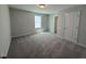 Spacious carpeted bedroom featuring natural light from a large window and a neutral color palette at 293 Gregory Village Dr, Lillington, NC 27546