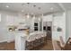 Bright kitchen features stainless appliances, white cabinetry, and large island at 293 Gregory Village Dr, Lillington, NC 27546
