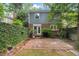 Serene backyard featuring a brick patio, manicured greenery, and privacy landscaping at 3025 Wycliff Rd, Raleigh, NC 27607
