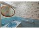 Bathroom featuring floral wallpaper, a round mirror, and blue tile at 3025 Wycliff Rd, Raleigh, NC 27607