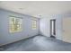 Bright bedroom with two windows offering a view of the outdoors, complemented by light blue walls and carpet at 3025 Wycliff Rd, Raleigh, NC 27607