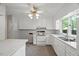 Bright kitchen with white cabinets, countertops, and a window overlooking the backyard at 3025 Wycliff Rd, Raleigh, NC 27607