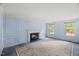 Cozy living room with a fireplace and paneled walls, bathed in natural light at 3025 Wycliff Rd, Raleigh, NC 27607