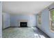 Cozy living room with fireplace, paneled walls, and natural light from the windows at 3025 Wycliff Rd, Raleigh, NC 27607