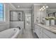 Bright bathroom with large soaking tub, glass shower, and double vanity at 3108 Lawson Walk Way, Rolesville, NC 27571