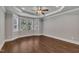 Bright bedroom featuring tray ceiling, large window, and hardwood floors at 3108 Lawson Walk Way, Rolesville, NC 27571