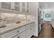 Convenient butler's pantry with white cabinets, granite countertops, and a tiled backsplash at 3108 Lawson Walk Way, Rolesville, NC 27571