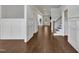 Long hallway with hardwood floors and wainscoting, connecting the foyer to other areas of the home at 3108 Lawson Walk Way, Rolesville, NC 27571