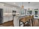 Modern kitchen with white cabinetry, granite countertops, stainless steel appliances, and seating at the island at 3108 Lawson Walk Way, Rolesville, NC 27571
