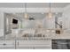 Kitchen island with stainless steel sink and granite countertop overlooking the living room with fireplace and ceiling fan at 3108 Lawson Walk Way, Rolesville, NC 27571