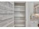 Walk-in pantry features custom shelving for optimized storage alongside kitchen with stone tile backsplash at 3108 Lawson Walk Way, Rolesville, NC 27571