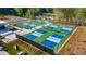 Aerial view of multiple pickleball courts surrounded by greenery and trees at 323 Beacon Dr, Pittsboro, NC 27312