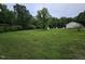 Wide shot of the backyard with storage shed and wooded perimeter at 3669 W Greensboro Chapel Hill Rd, Liberty, NC 27298