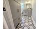 Hallway leading to a bathroom featuring built-in storage and stylish hexagon tile floors at 3669 W Greensboro Chapel Hill Rd, Liberty, NC 27298