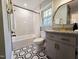 This remodeled bathroom features stylish hexagon floors, grey cabinets, and white tile in the shower at 3669 W Greensboro Chapel Hill Rd, Liberty, NC 27298