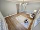 The stylish bedroom features plenty of sunlight, hardwood floors, and modern chandelier at 3669 W Greensboro Chapel Hill Rd, Liberty, NC 27298