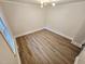 Empty bedroom featuring hardwood floors, white trim, and a modern light fixture at 3669 W Greensboro Chapel Hill Rd, Liberty, NC 27298