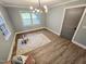 Light-filled bedroom features wood floors, modern light fixture and many windows at 3669 W Greensboro Chapel Hill Rd, Liberty, NC 27298