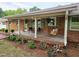 Inviting front porch with a swing, seating area, and lovely landscaping at 3669 W Greensboro Chapel Hill Rd, Liberty, NC 27298