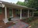 Inviting front porch with a swing, seating area, and lovely landscaping at 3669 W Greensboro Chapel Hill Rd, Liberty, NC 27298