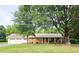 Charming brick ranch-style home with attached garage, mature trees and a well-manicured lawn at 3669 W Greensboro Chapel Hill Rd, Liberty, NC 27298