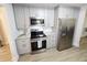 Modern kitchen featuring stainless steel appliances, stylish countertops, and sleek grey cabinets at 3669 W Greensboro Chapel Hill Rd, Liberty, NC 27298