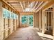 Spacious room with exposed framing and windows, showcasing the unfinished interior ready for customization with outdoor views at 3824 Coach Lantern Ave, Wake Forest, NC 27587