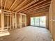 Interior with exposed framing reveals a sliding glass door and layout potential in the unfinished space, awaiting personalization at 3824 Coach Lantern Ave, Wake Forest, NC 27587