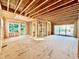 Unfinished interior reveals exposed framing, large windows, and a sliding door with exterior views, highlighting the home's potential at 3824 Coach Lantern Ave, Wake Forest, NC 27587