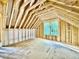 Unfinished attic area with wood framing, exposed beams and sheeting, and a single window overlooking nature at 3828 Coach Lantern Ave, Wake Forest, NC 27587