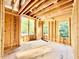 Unfinished bedroom with wood framing, exposed beams and sheeting, and lots of natural light streaming through the windows at 3828 Coach Lantern Ave, Wake Forest, NC 27587