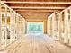 Hallway with exposed beams and framing, offering a view to the exterior, and showcasing the home's construction at 3828 Coach Lantern Ave, Wake Forest, NC 27587