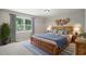 Stylish bedroom with a wooden bed frame, blue accents, and a large window overlooking the exterior at 3916 W Allen, Raleigh, NC 27603