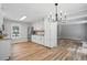 Spacious kitchen with white cabinetry, stainless steel refrigerator, modern light fixture, and wood-look flooring at 3916 W Allen, Raleigh, NC 27603