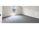 Bright bedroom featuring neutral walls, gray carpeting, a window, and a storage door at 4025 Scofield Dr, Raleigh, NC 27610
