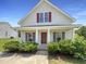 Charming home showcasing a covered front porch, attractive landscaping, and red shutters at 4025 Scofield Dr, Raleigh, NC 27610