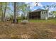 View of backyard with fire pit, swing, fenced yard, and elevated screened in porch at 4036 Mackenzie Dr, Haw River, NC 27258