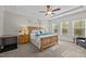 Spacious bedroom featuring a tray ceiling, many windows, and a cozy seating area at 4036 Mackenzie Dr, Haw River, NC 27258