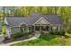 Charming home with stone accents, inviting front porch, beautiful landscaping, and a well-maintained lawn at 4036 Mackenzie Dr, Haw River, NC 27258