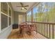 Inviting porch with wooden furniture, ceiling fan and view of wooded backyard at 4036 Mackenzie Dr, Haw River, NC 27258
