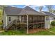 View of an elevated and screened-in porch with stairs leading down, and deck with grill at 4036 Mackenzie Dr, Haw River, NC 27258