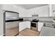 Bright kitchen with white cabinetry, stainless steel appliances, and gray countertops at 404 Southerby Dr, Garner, NC 27529