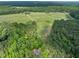 Expansive aerial view of the property including mature trees, lush lawns, and open land at 406 Johns Woods Rd, Chapel Hill, NC 27516