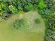 Aerial image of an open lawn with a ring of stones and beautiful surrounding trees and greenery at 406 Johns Woods Rd, Chapel Hill, NC 27516