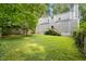 Wide shot of the home and backyard featuring a lush lawn and access to the home's rear entrance at 406 Johns Woods Rd, Chapel Hill, NC 27516