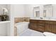 Bright bathroom featuring a soaking tub and double sink vanity at 406 Johns Woods Rd, Chapel Hill, NC 27516