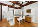 Eat-in kitchen featuring wood beams, white cabinets, and a breakfast bar at 406 Johns Woods Rd, Chapel Hill, NC 27516