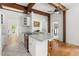 Bright kitchen with wooden beams, white cabinetry, and stainless steel range at 406 Johns Woods Rd, Chapel Hill, NC 27516