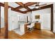 Eat-in kitchen featuring wood beams, white cabinets, and a breakfast bar at 406 Johns Woods Rd, Chapel Hill, NC 27516